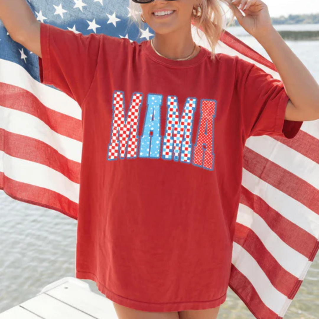 Comfort Colors graphic t-shirt featuring patriotic MAMA lettering with red, white, and blue patterns on multiple shirt color options.