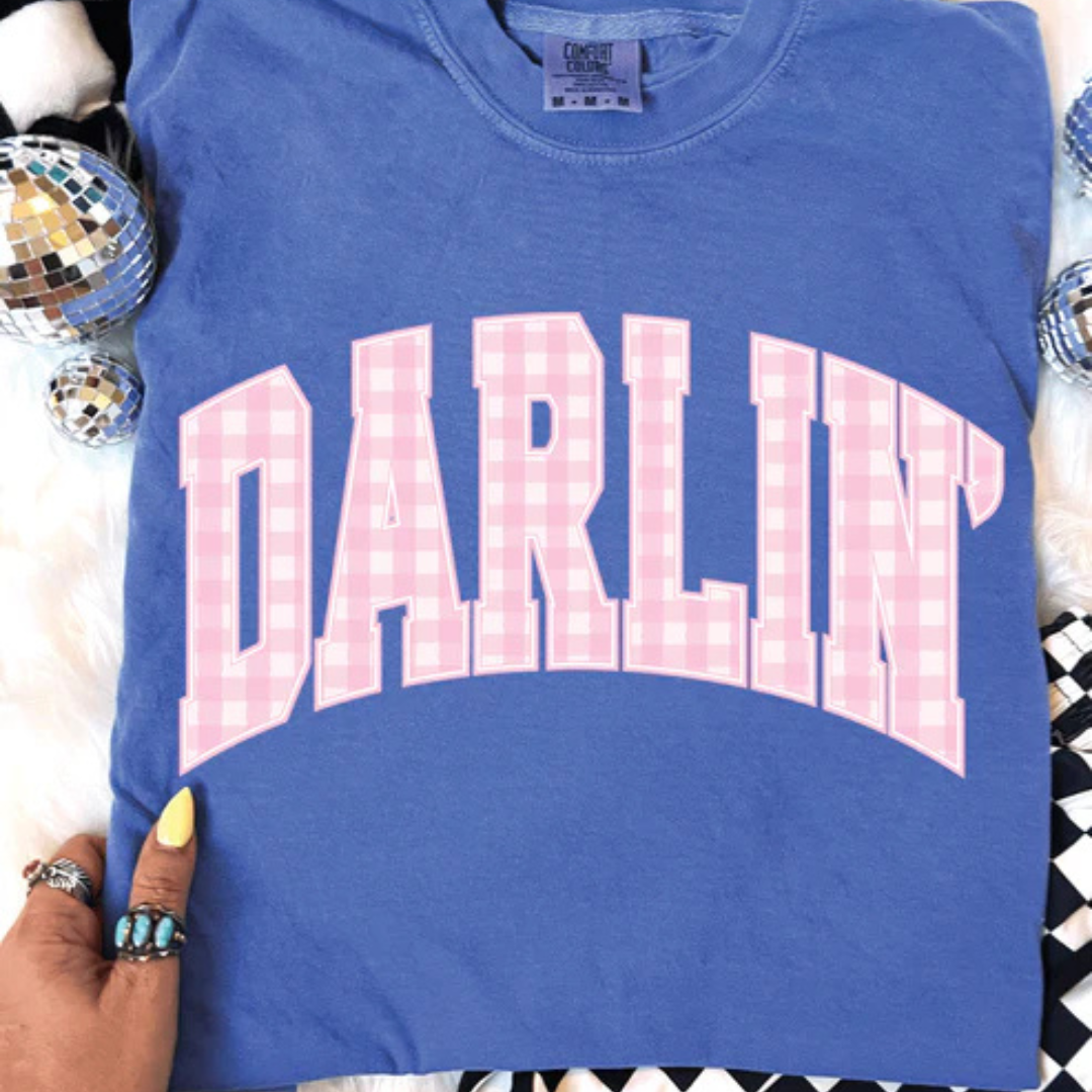 Flo Blue Comfort Colors t-shirt featuring a large Darlin' graphic with pink gingham varsity-style lettering.