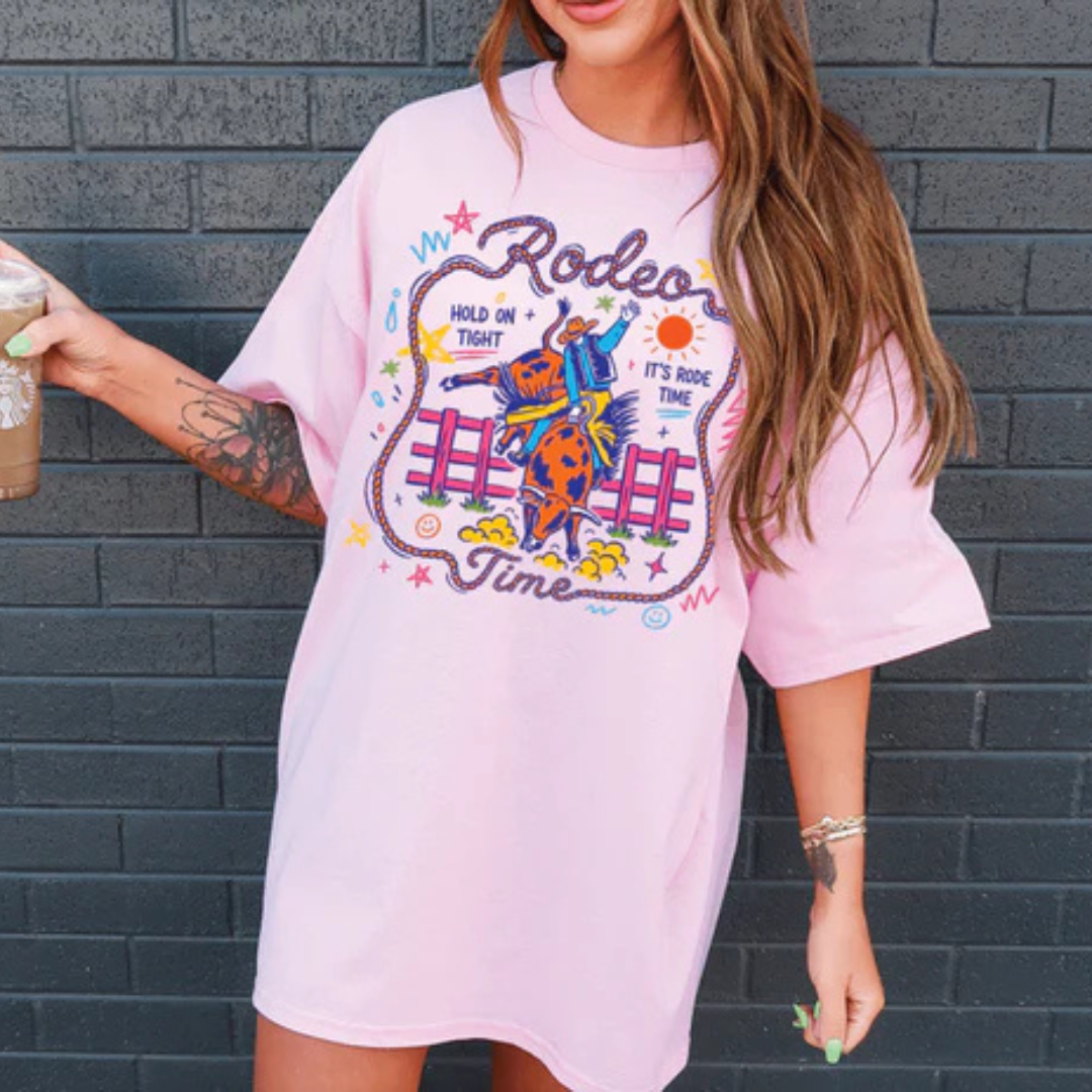 Graphic t-shirt featuring a colorful rodeo bronc rider design with Rodeo Time text and western-inspired artwork in multiple color options.