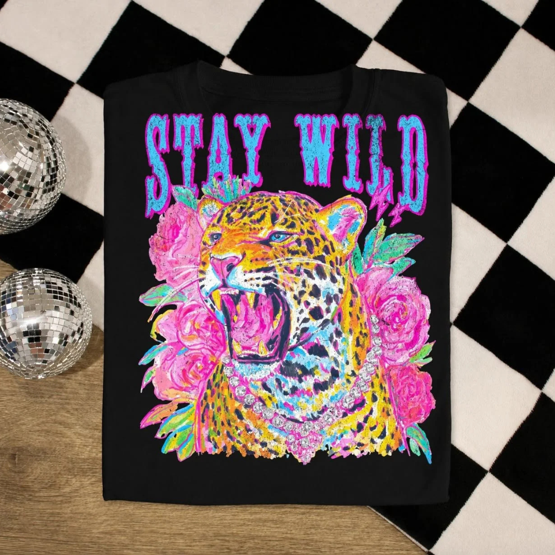 Black graphic tee featuring a colorful leopard graphic with pink flowers and Stay Wild lettering.