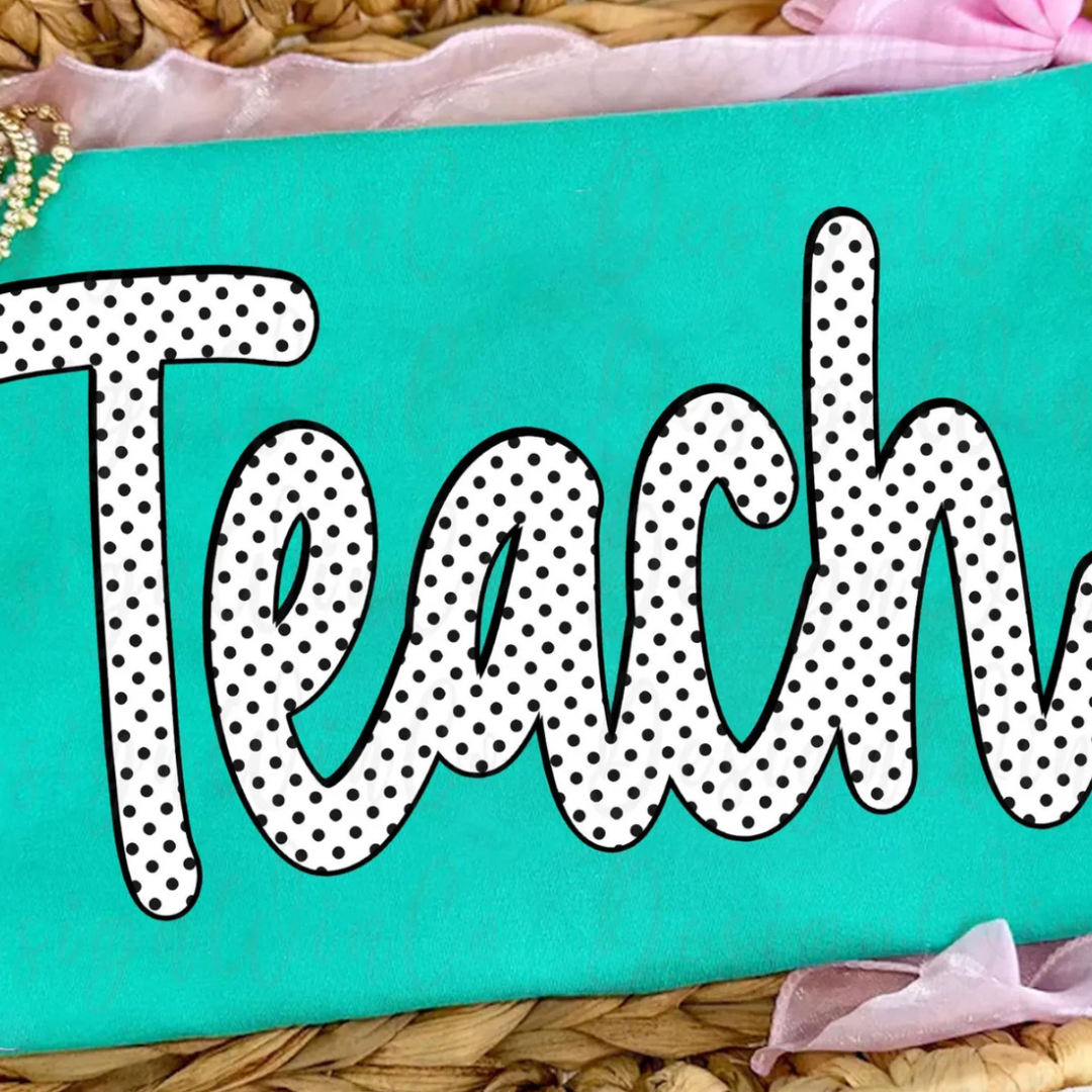 Turquoise blue graphic tee featuring a large black and white polka dot script design that reads "Teach."