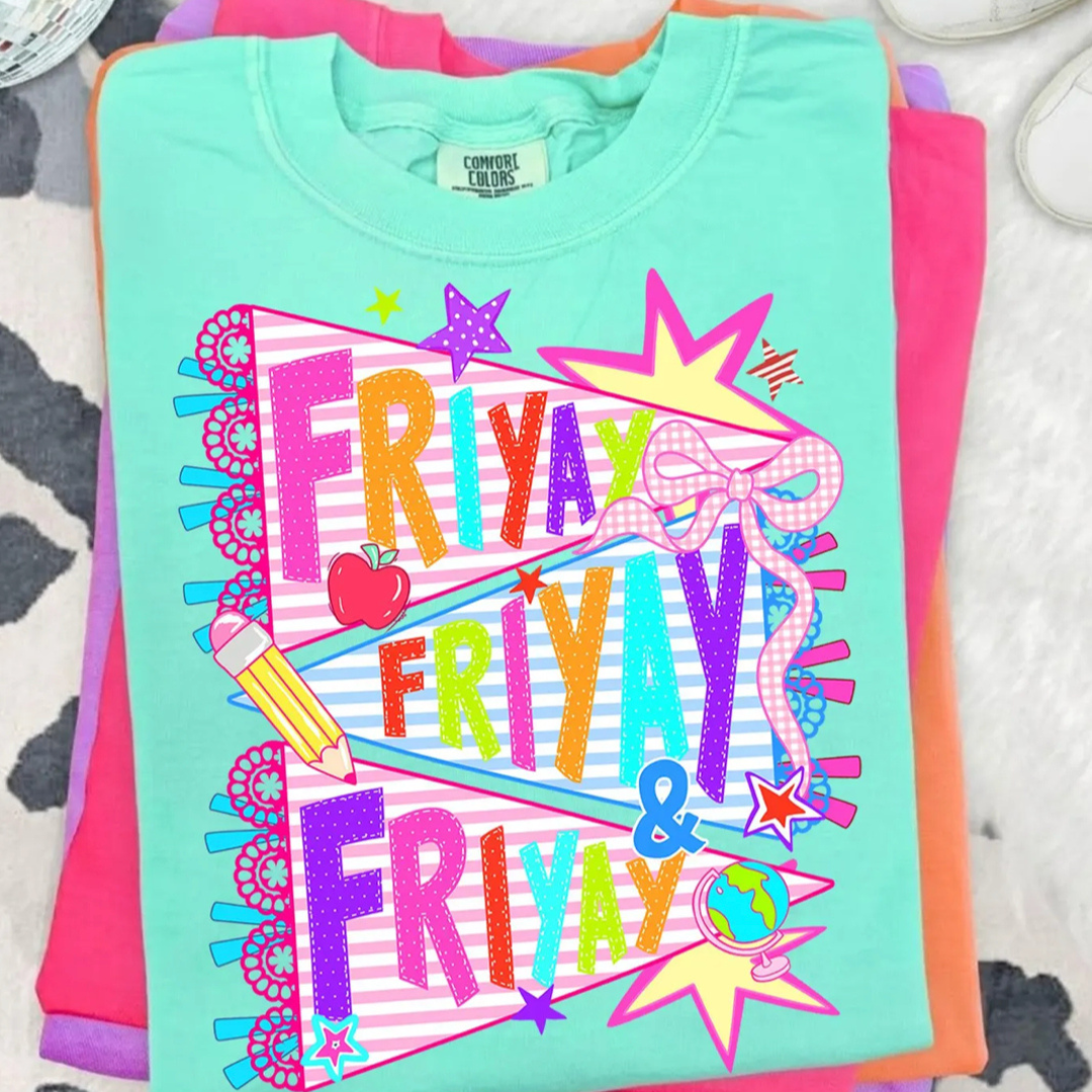Turquoise blue graphic tee featuring an oversized pencil with colorful classroom illustrations including an apple, ruler, flowers, book, and paper airplane.