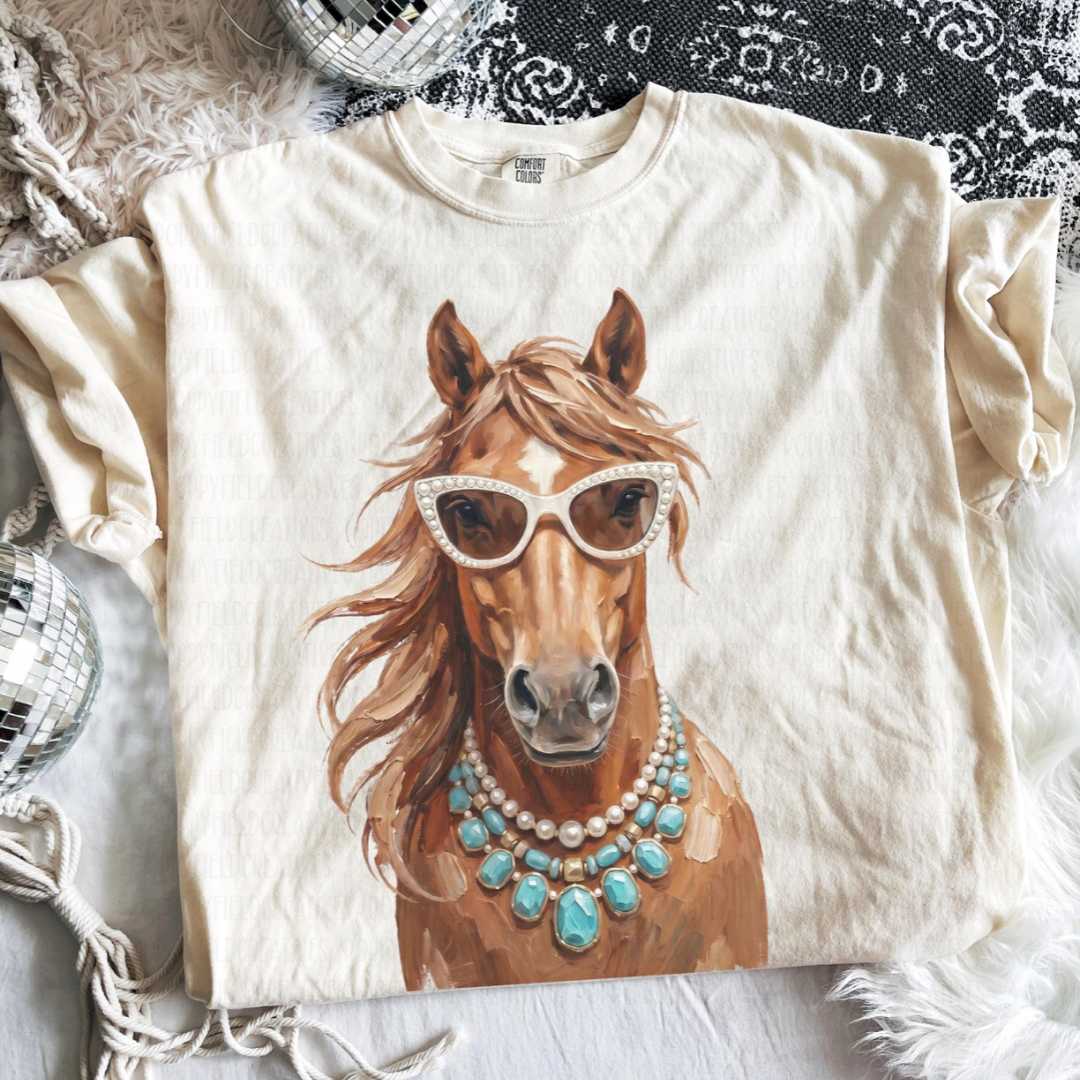 Natural graphic tee featuring a stylish horse wearing pearl sunglasses and layered turquoise statement jewelry.