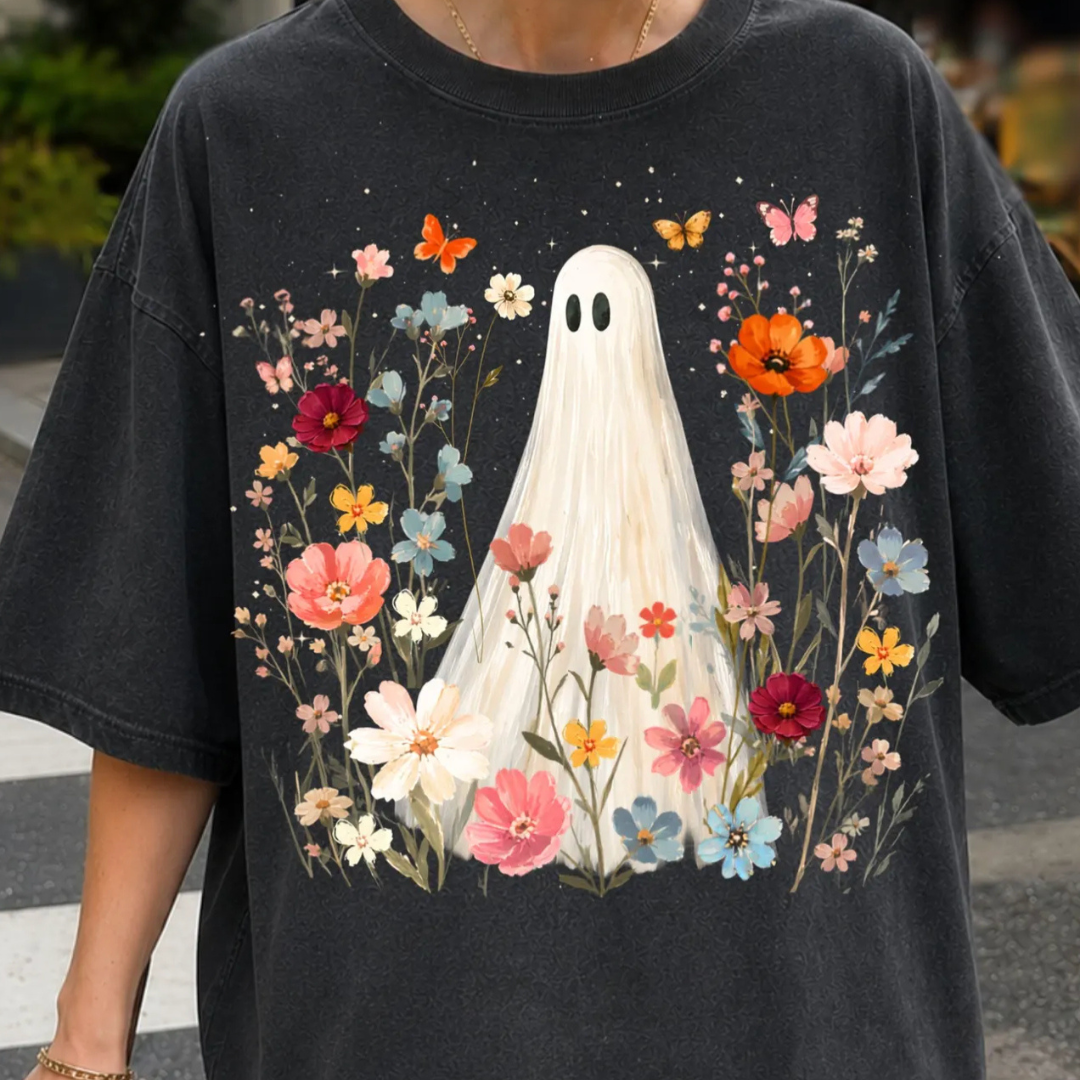 Vintage black graphic tee featuring a white ghost standing among colorful wildflowers with butterflies and delicate botanical artwork.
