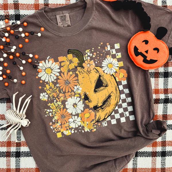 Brown sweatshirt with Halloween-themed design featuring a pumpkin and flowers on a checkered background.