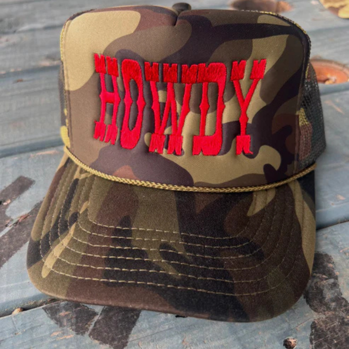 Camouflage trucker hat featuring bold red embroidered Howdy lettering with an adjustable mesh back.