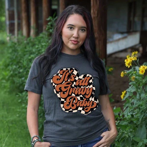 Woman wearing a t-shirt with 'It's all gravy baby' text in a garden setting