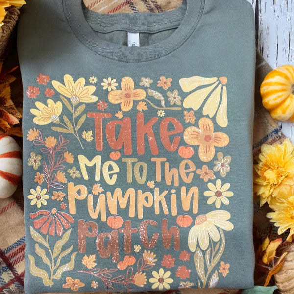 Sweatshirt with 'Take Me to the Pumpkin Patch' design surrounded by autumn decorations.