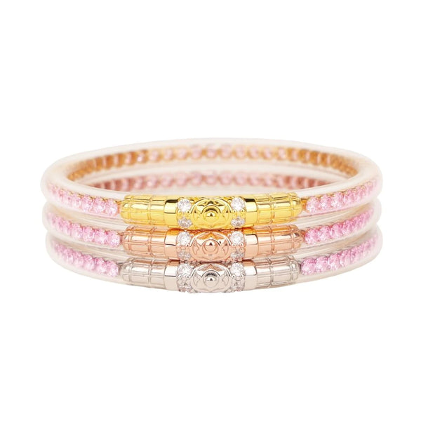 White background with three bracelets: gold, rose gold and silver (top to bottom) are shown with pink crystals inside a clear tube bracelet.