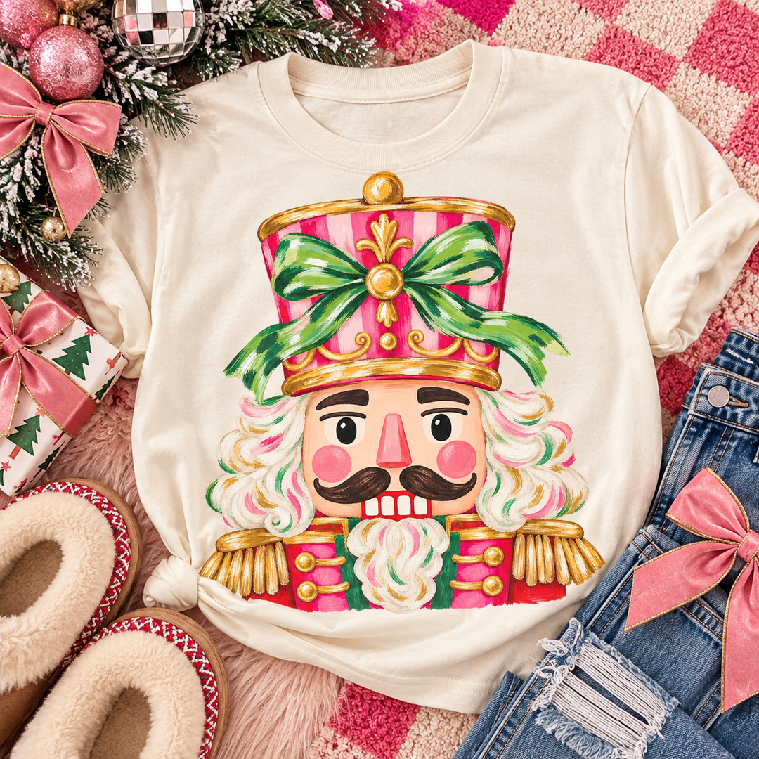 Pink and Green Nutcracker Christmas graphic tee or sweatshirt on ivory with a pink and green nutcracker with a bow on his hat