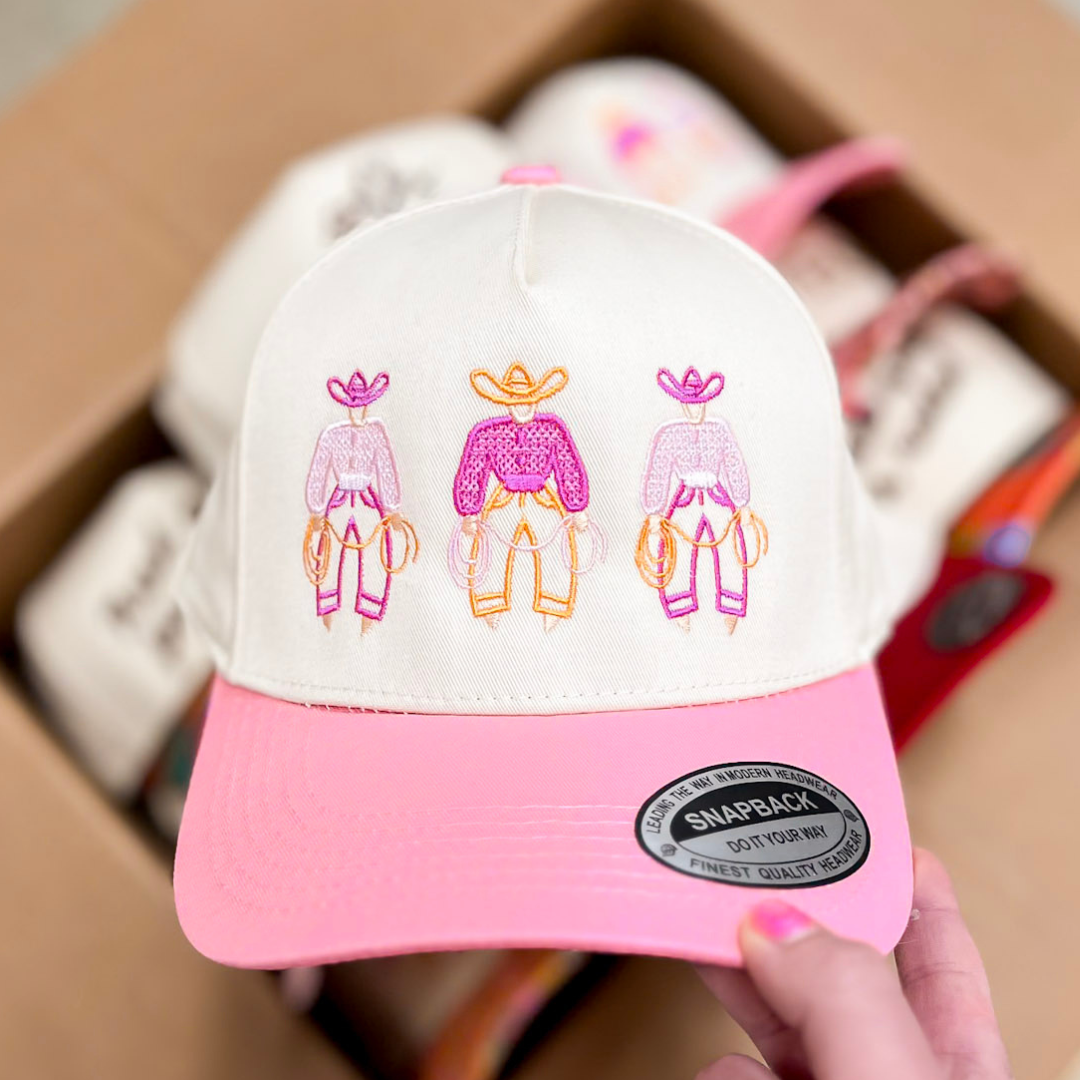 Cream trucker hat with embroidered Pink cowgirl trio design and soft pink brim.