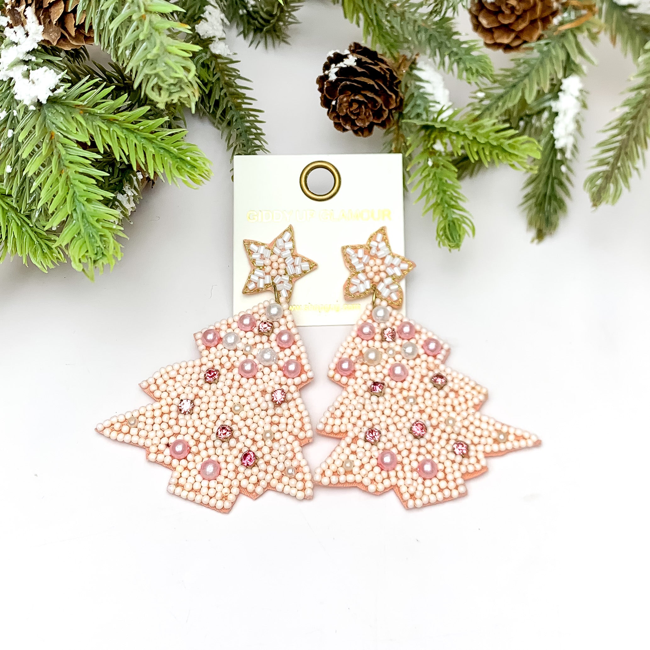Pink Holidays Beaded Christmas Tree Earrings With Pearls. These earrings are pictured on a white background with a tree and pine cones at the top.