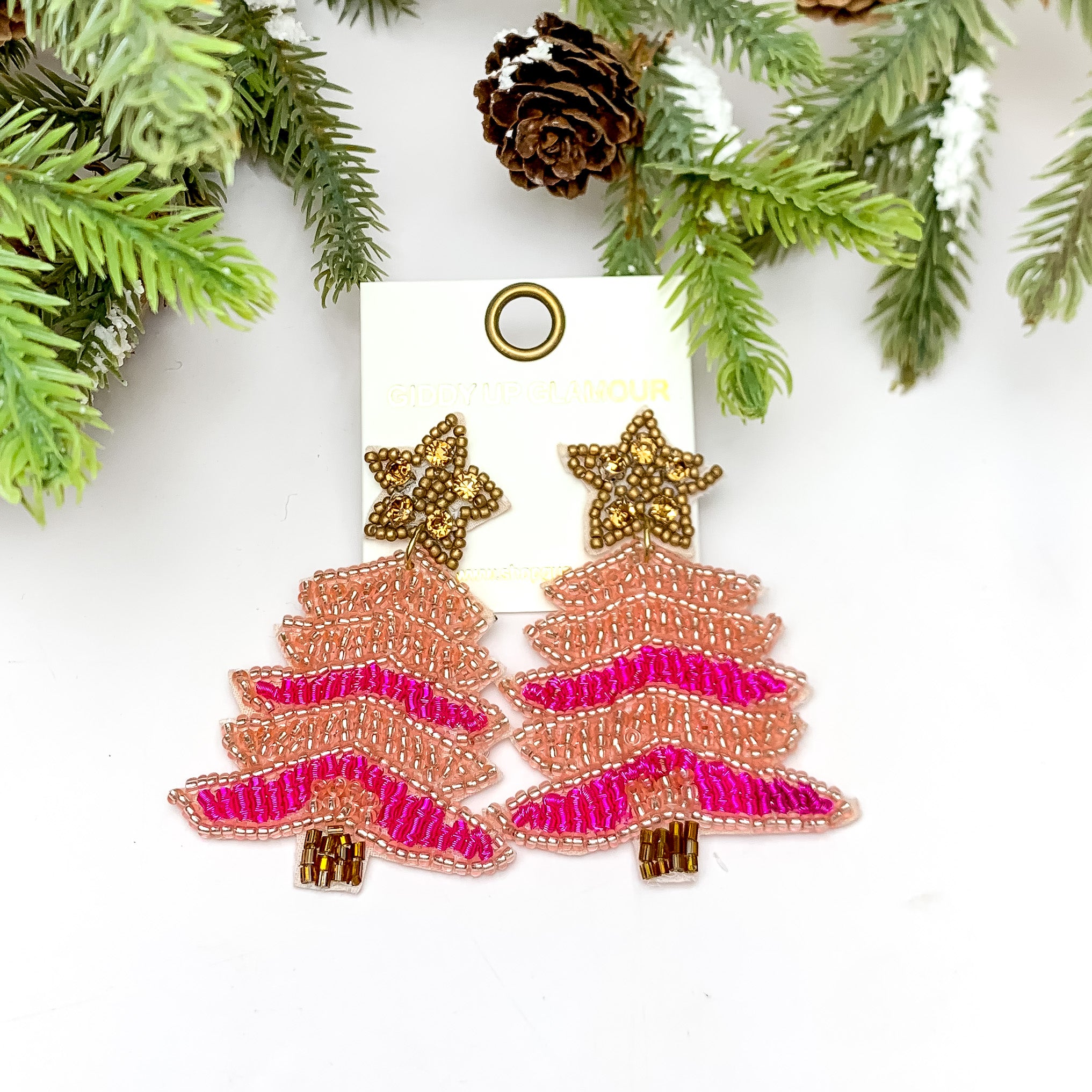 Pink Shades Beaded Christmas Tree Earrings With Gold Star Post. These earrings are pictured on a white background with a tree and pine cones at the top.