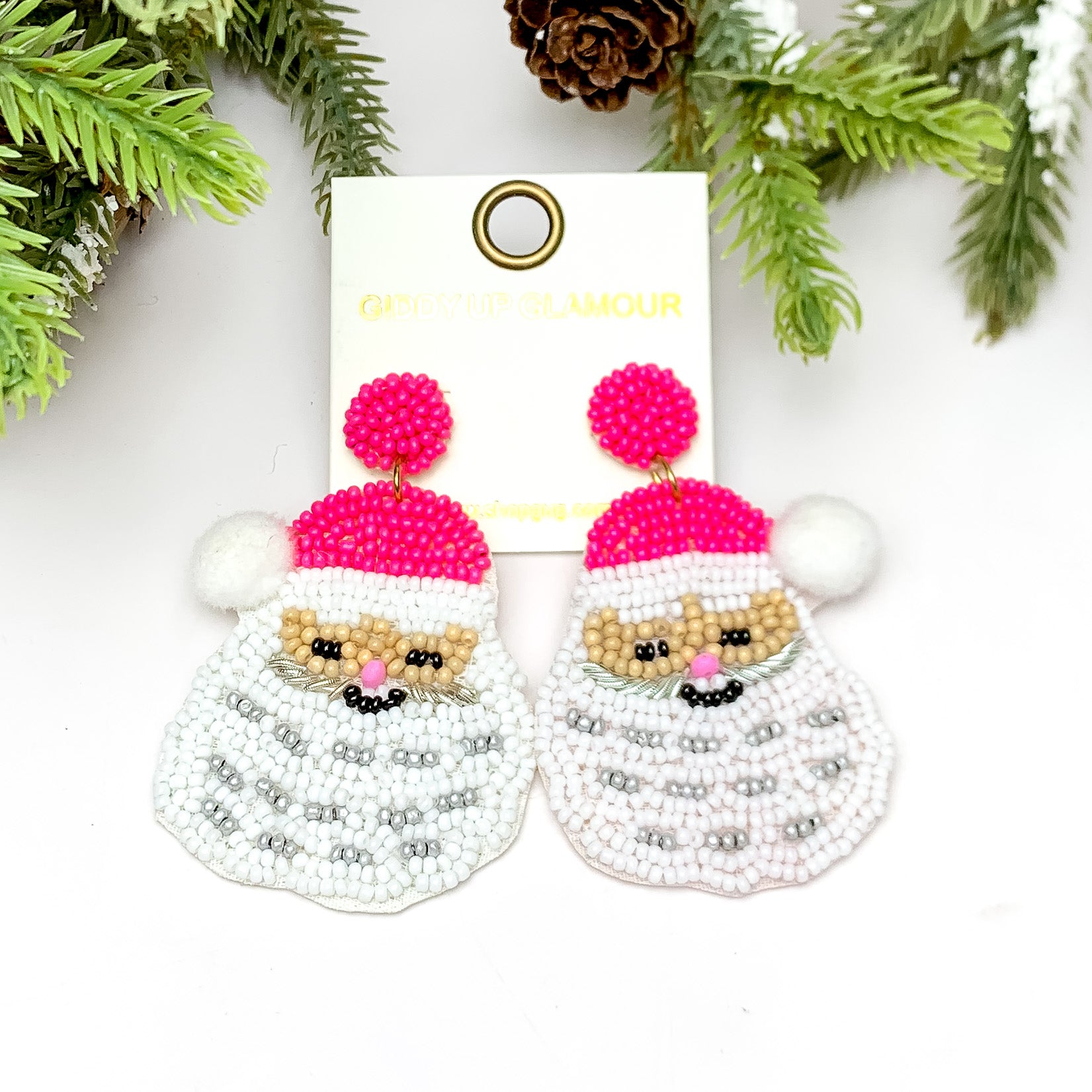 Pretty in Pink Santa Beaded Earrings. These earrings are pictured on a white background with a tree and pine cones at the top.