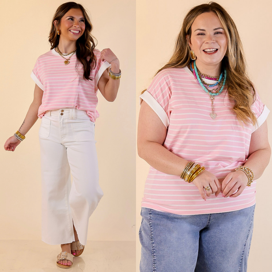 Two women wearing pink striped shirts with different pants on a beige background