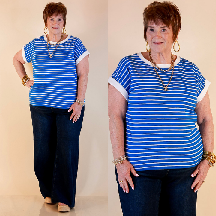 Models are wearing Scoop Neck Cap Sleeve with Contrast Trim Striped Tee top in Dark Blue with Jeans against a beige backdrop.