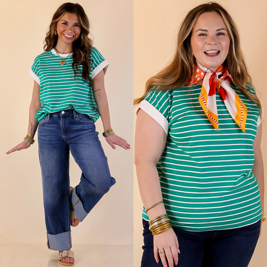 Two women wearing green and white striped shirts with blue jeans on a beige background