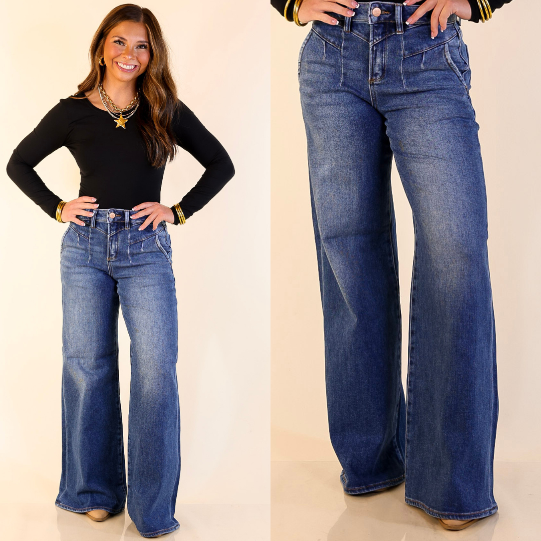 Woman wearing Wide Leg Front Yoke Seam Detail Jeans in Dark Wash with a plain background