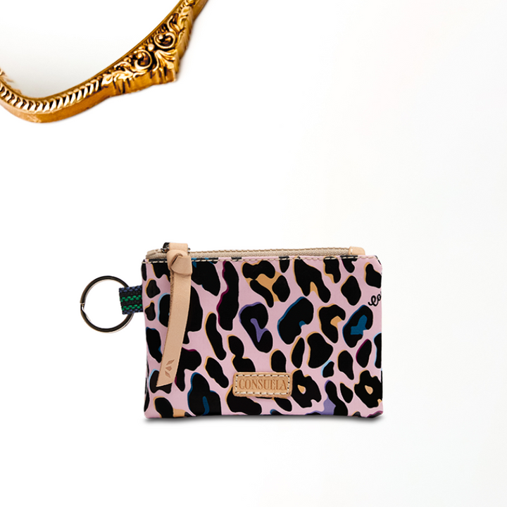 A solid white background with a gold mirror decal. Ruth is a colorful jag print with genuine leather zipper and Consuela logo. This pouch has interior card holding slots. A ring is attached perfect for adding keys! 