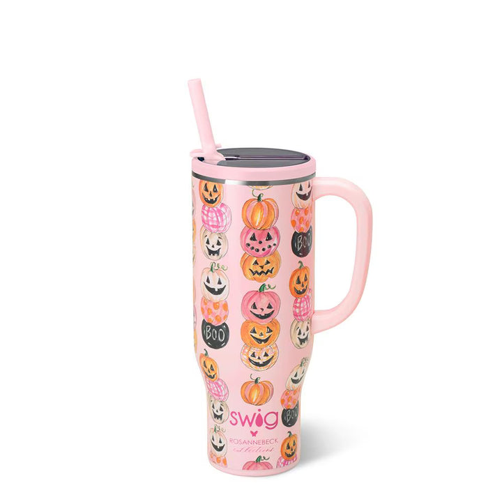A pink handled travel tumbler with a lid and straw, decorated with a pattern of jack-o&