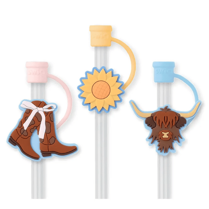 3 reusable straws with 3 silicone toppers. A colored cap that covers the straw opening. Each topper has a icon on it (left to right) Cowgirl boots with white bow, sunflower, long-haired cow head.