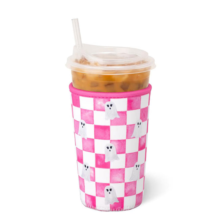 A pink and white checkered foam cup sleeve on a clear plastic cup with a straw, filled with iced coffee, on a white background.