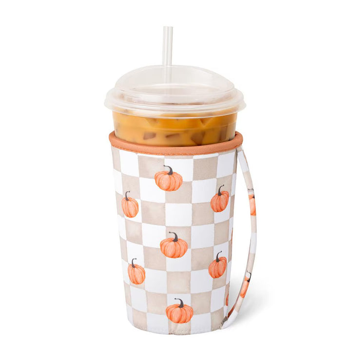 Iced cup coolie sleeve in a tan and white pumpkin check print with a wrist strap, shown on an iced coffee cup.