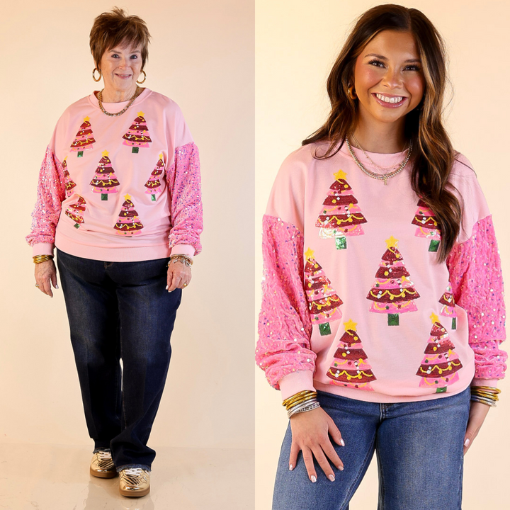 Models are wearing pink sweatshirts with sequined Christmas tree icons with velvet sleeves on a beige background.