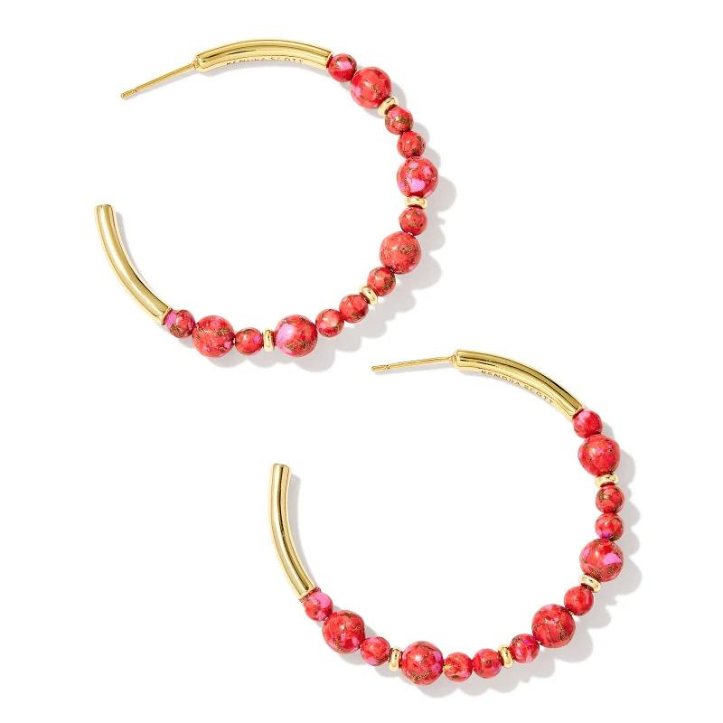 Gold hoop earrings with red marble beads in varying sizes. These earrings are pictured on a white background. 
