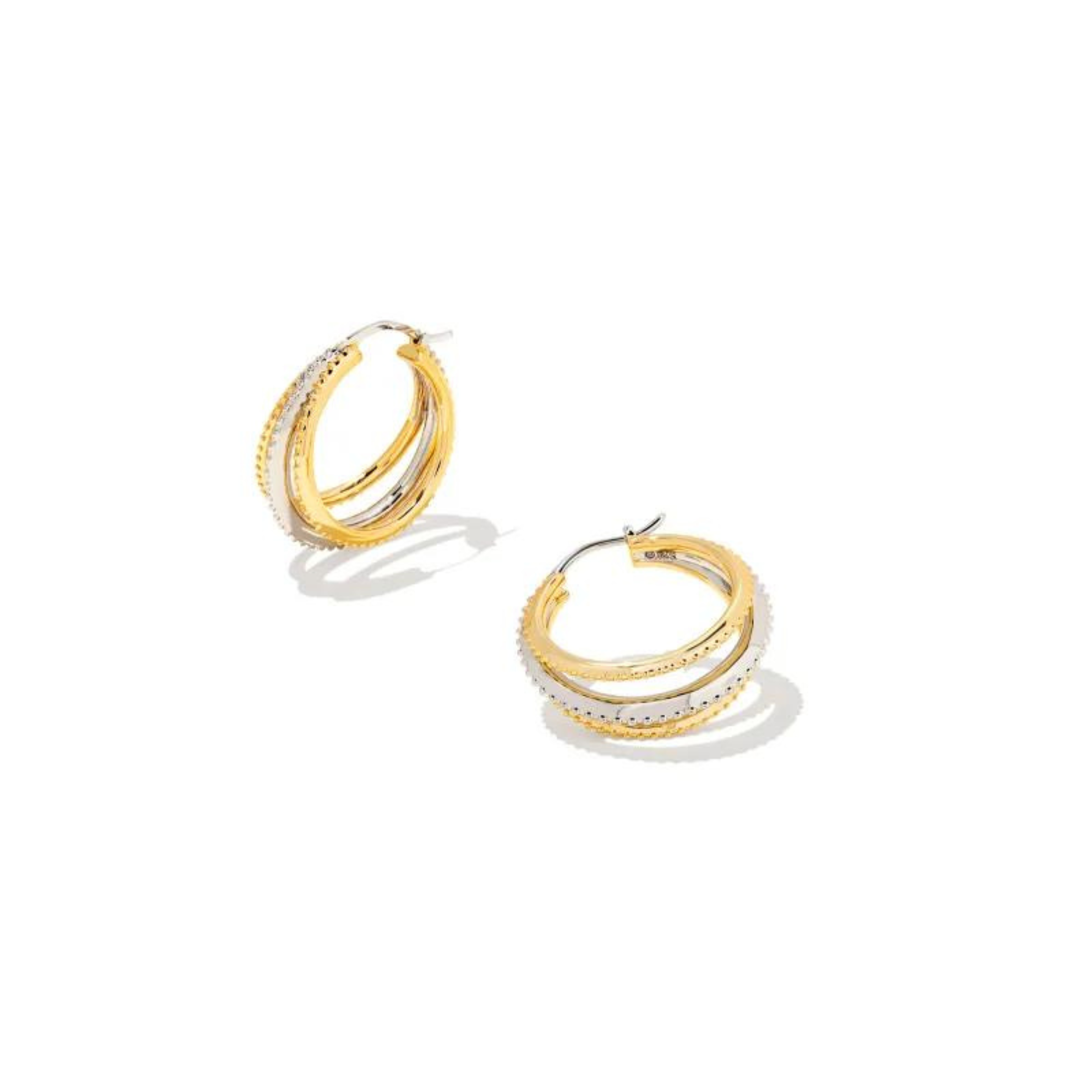 Triple layered hoop earrings. The two outer hoops are gold and the center hoop is silver. These earrings are pictured on a white background. 