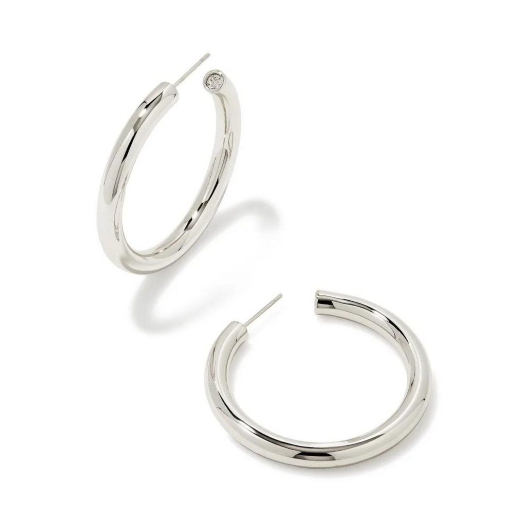 Pictured is a pair of silver hoop earrings on a white background.