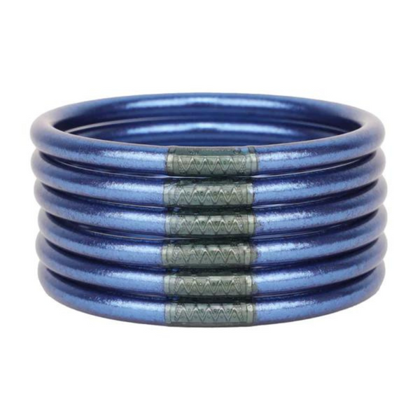 Six royal blue bracelets pictured stacked on top of each other on a white background. 