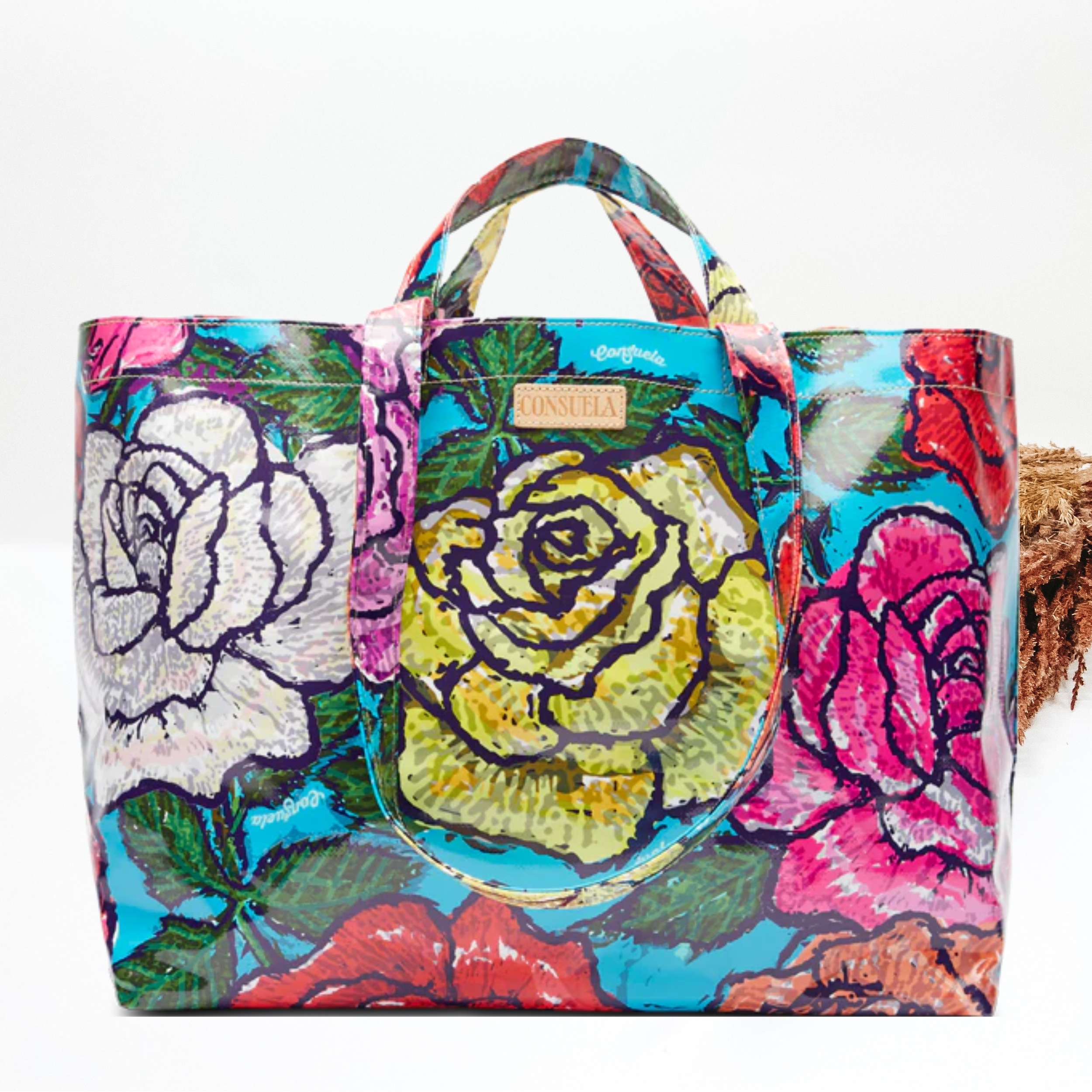 Pictured partially on a white background is a blue bag with a multicolor rose design with green leaves.  