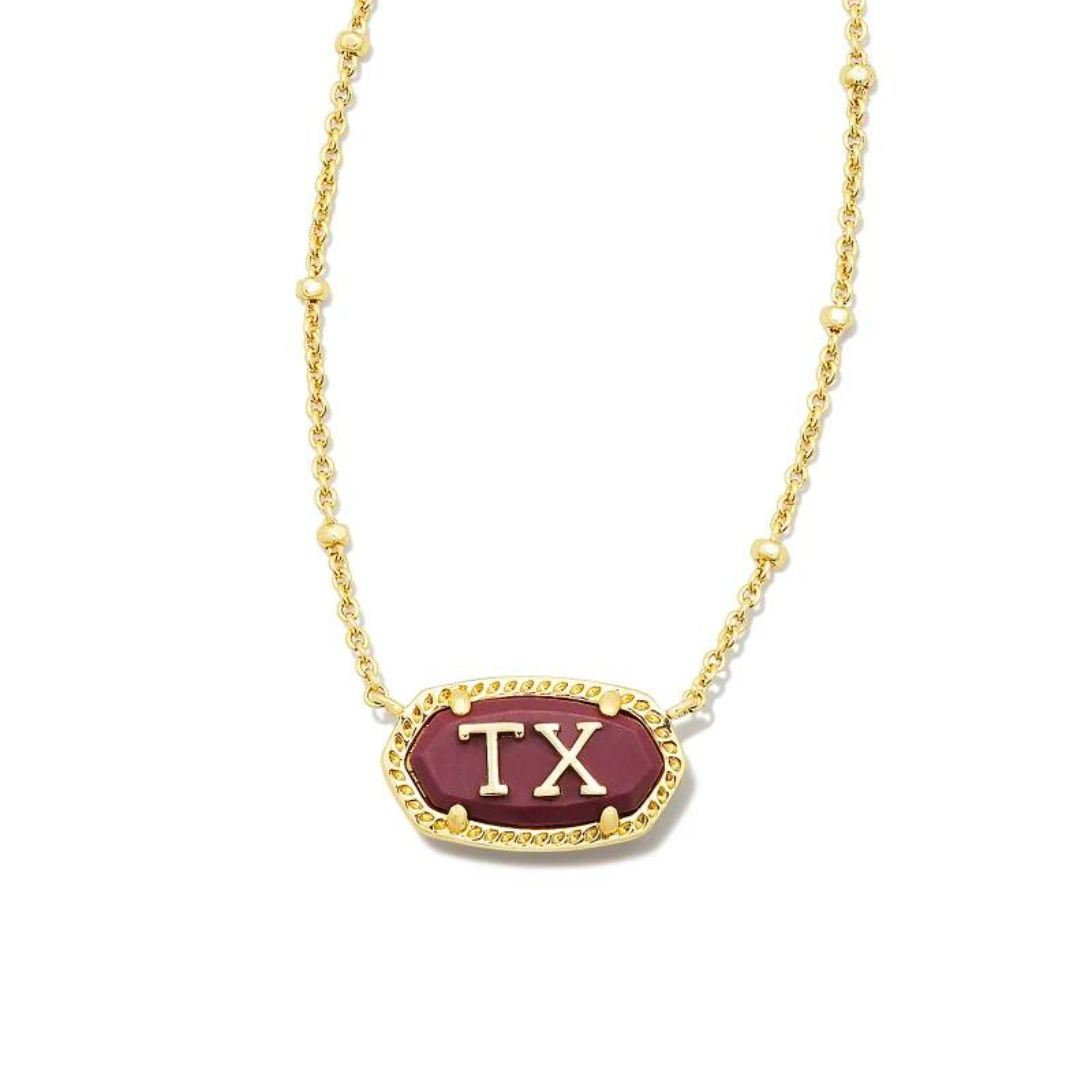 Pictured on a white background is a gold chain necklace with a maroon stone, oval pendant. This pendant has a gold outline and gold "TX" in the center.  