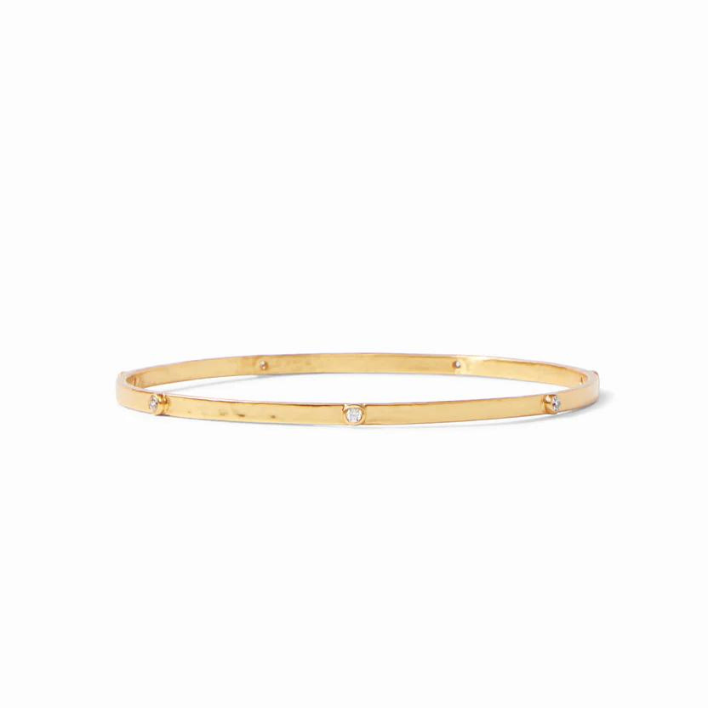 Gold, hammered bangle with clear crystals. This bracelet is pictured on a white background. 