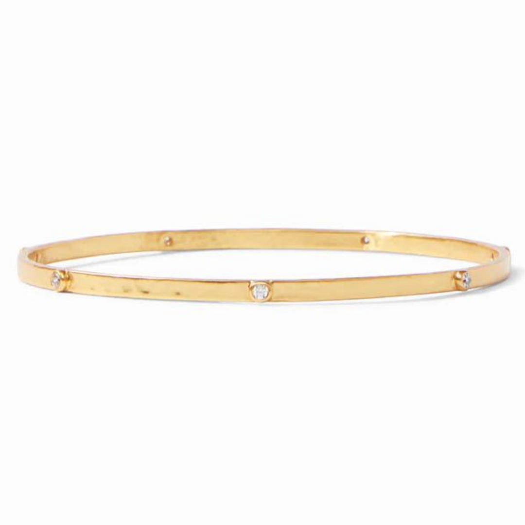 Gold, hammered bangle with clear crystals. This bracelet is pictured on a white background. 