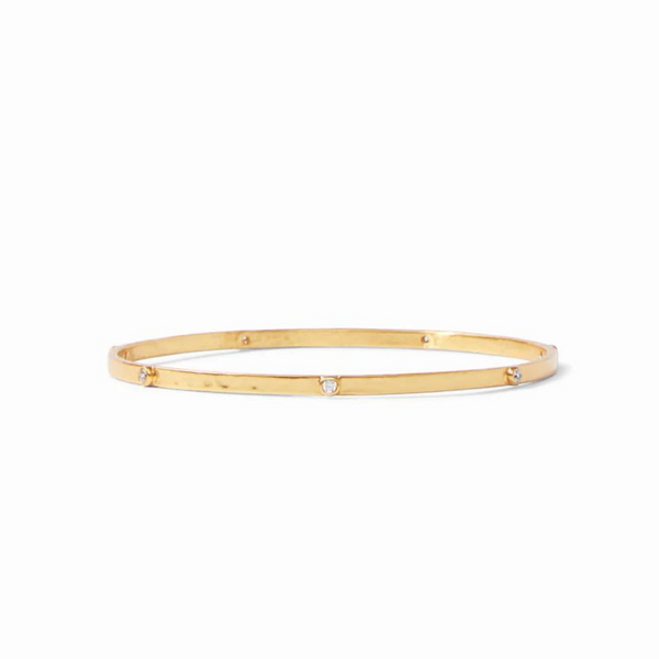 Gold, hammered bangle with clear crystals. This bracelet is pictured on a white background. 