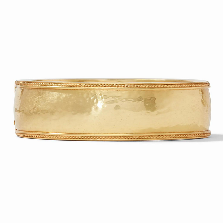 Gold, hammered bangle pictured on a white background. 