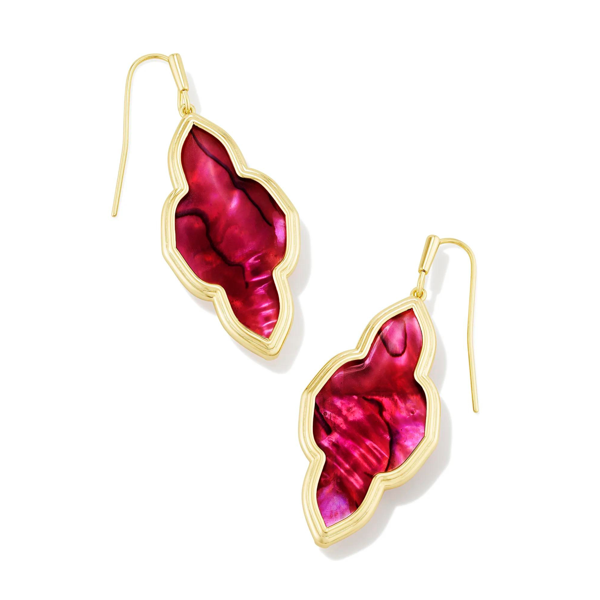 Pictured is a a pair of gold drop earrings in the abbie shape on a white background. These earrings include a gold outline with a light burgundy illusion stone.  