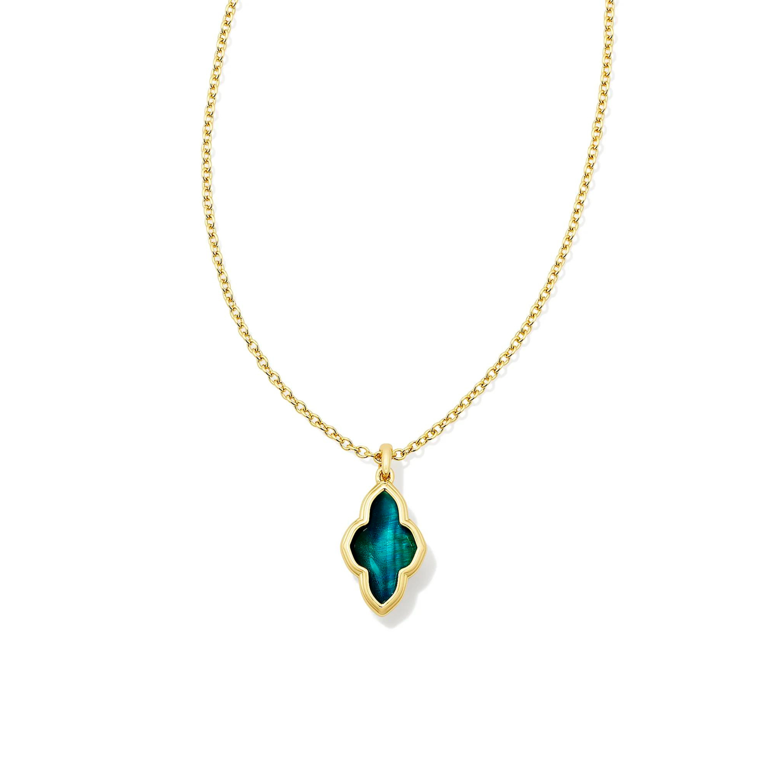 Pictured is a gold chain necklace with an abbie shaped necklace on a white background. This necklace includes a gold outline with a teal tiger's eye stone.  