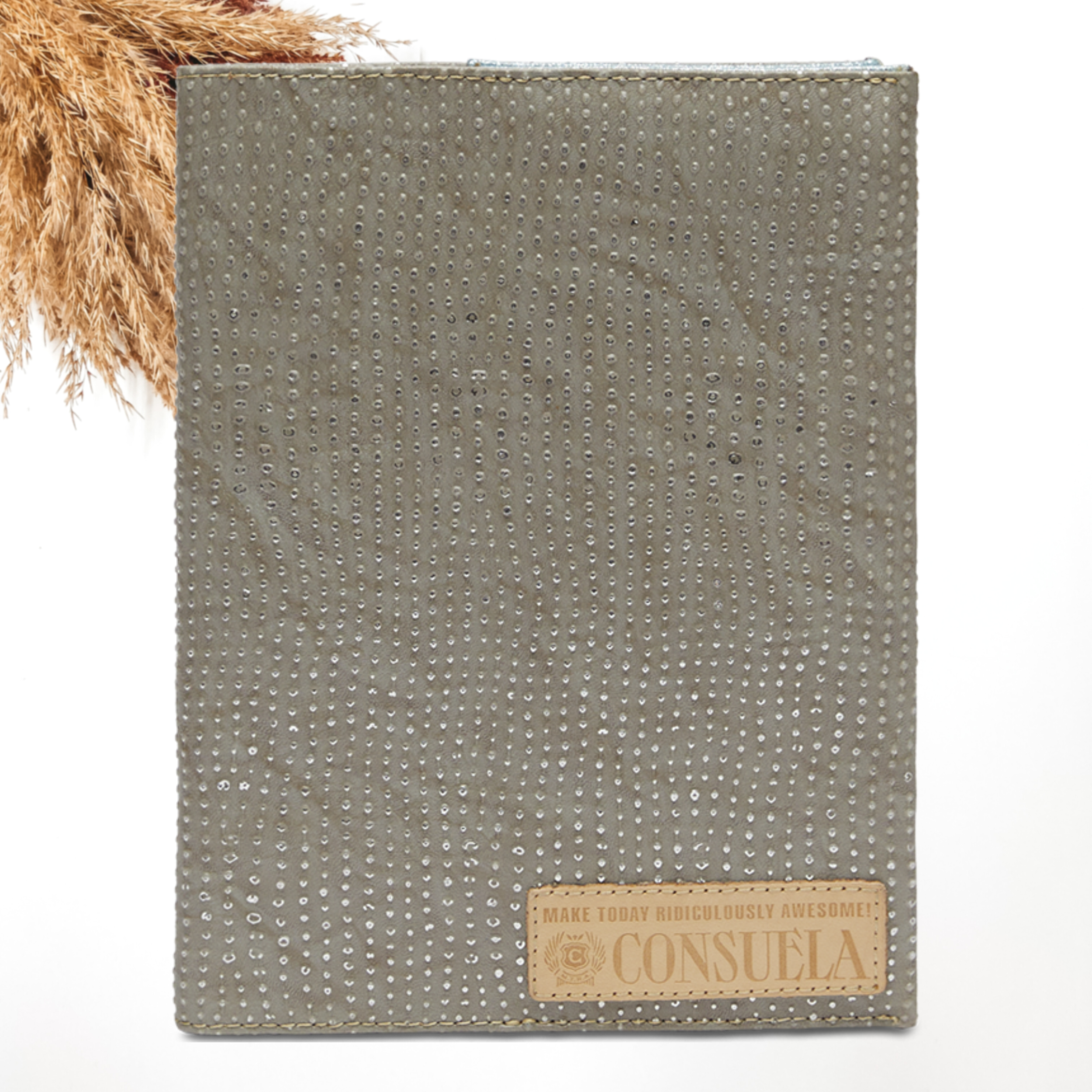 Pictured on a white background is a grey notebook cover with a dotted print. This notebook includes a light tan leather patch on the bottom right corner.