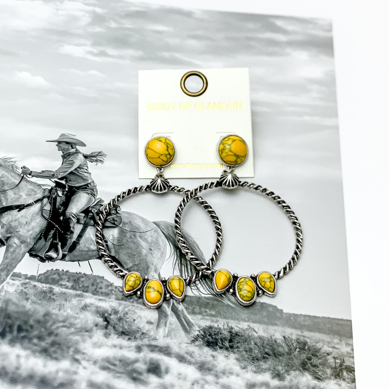 Western Moment Silver Tone Hoop Earrings With Stones in Yellow. Pictured with a western scene in the back.