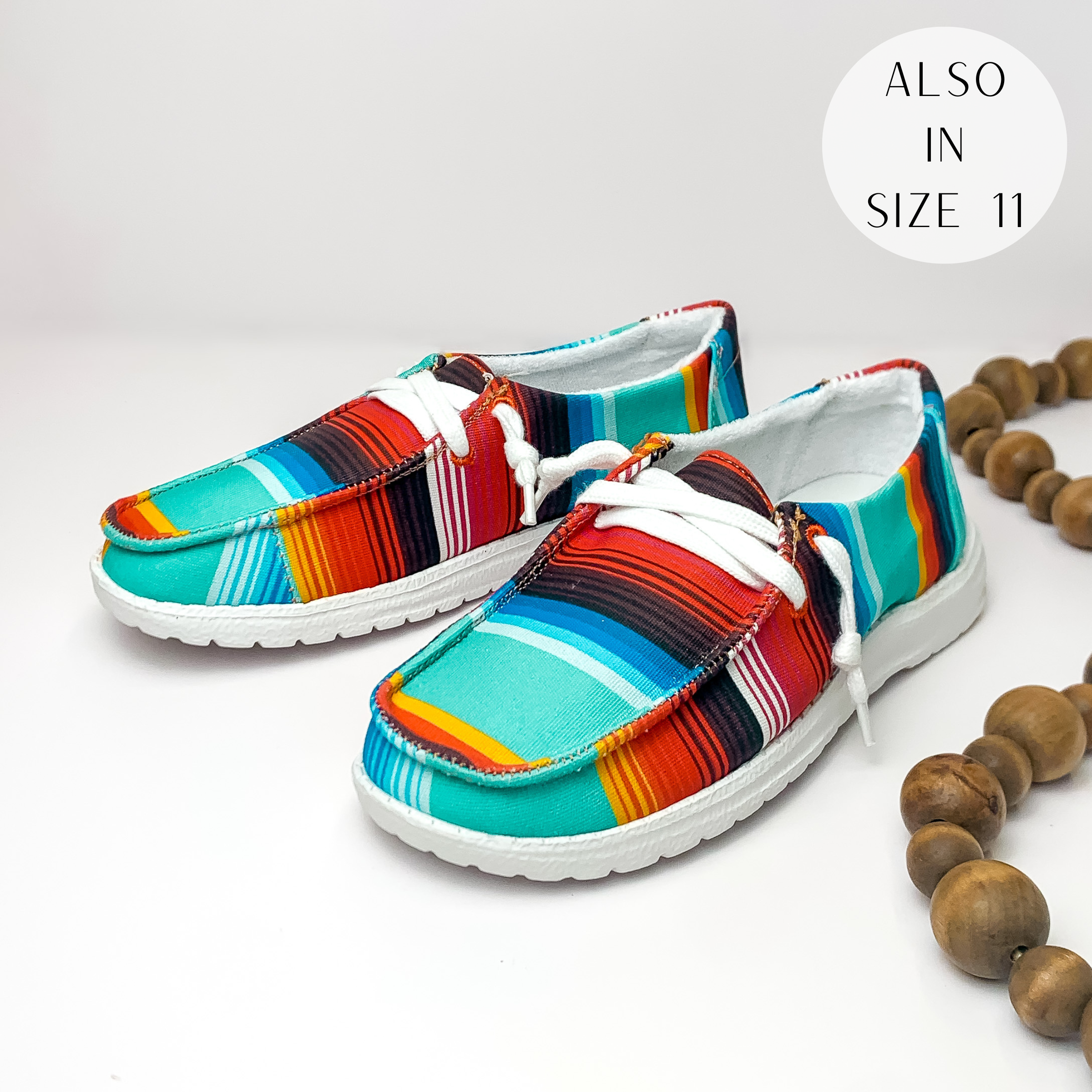 Multicolored serape print shoes with white laces. These shoes are pictured on a white background with brown beads on the right side.