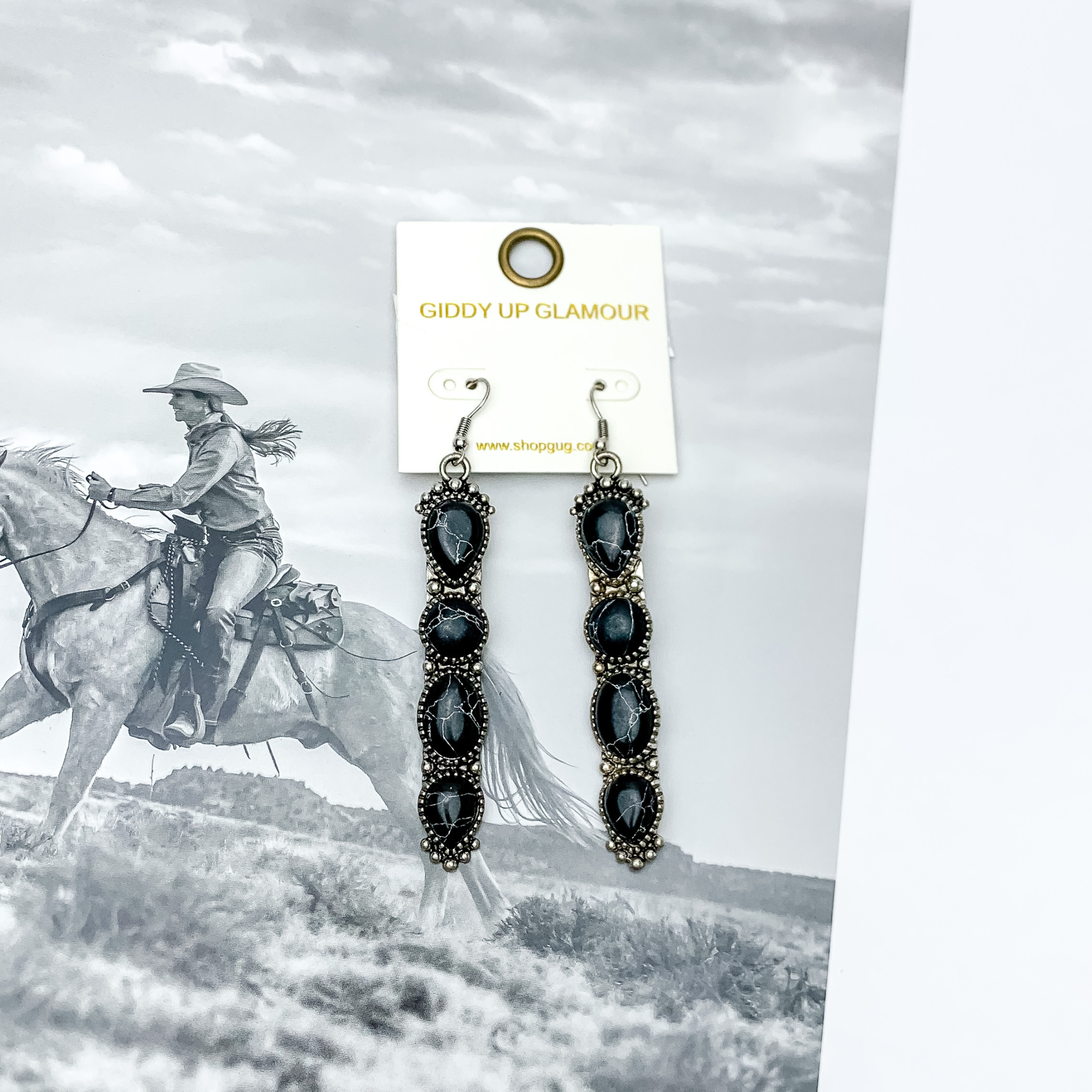 Western Connection Silver Tone Earrings With Four Stones in Red. Pictured with a western scene in the background.