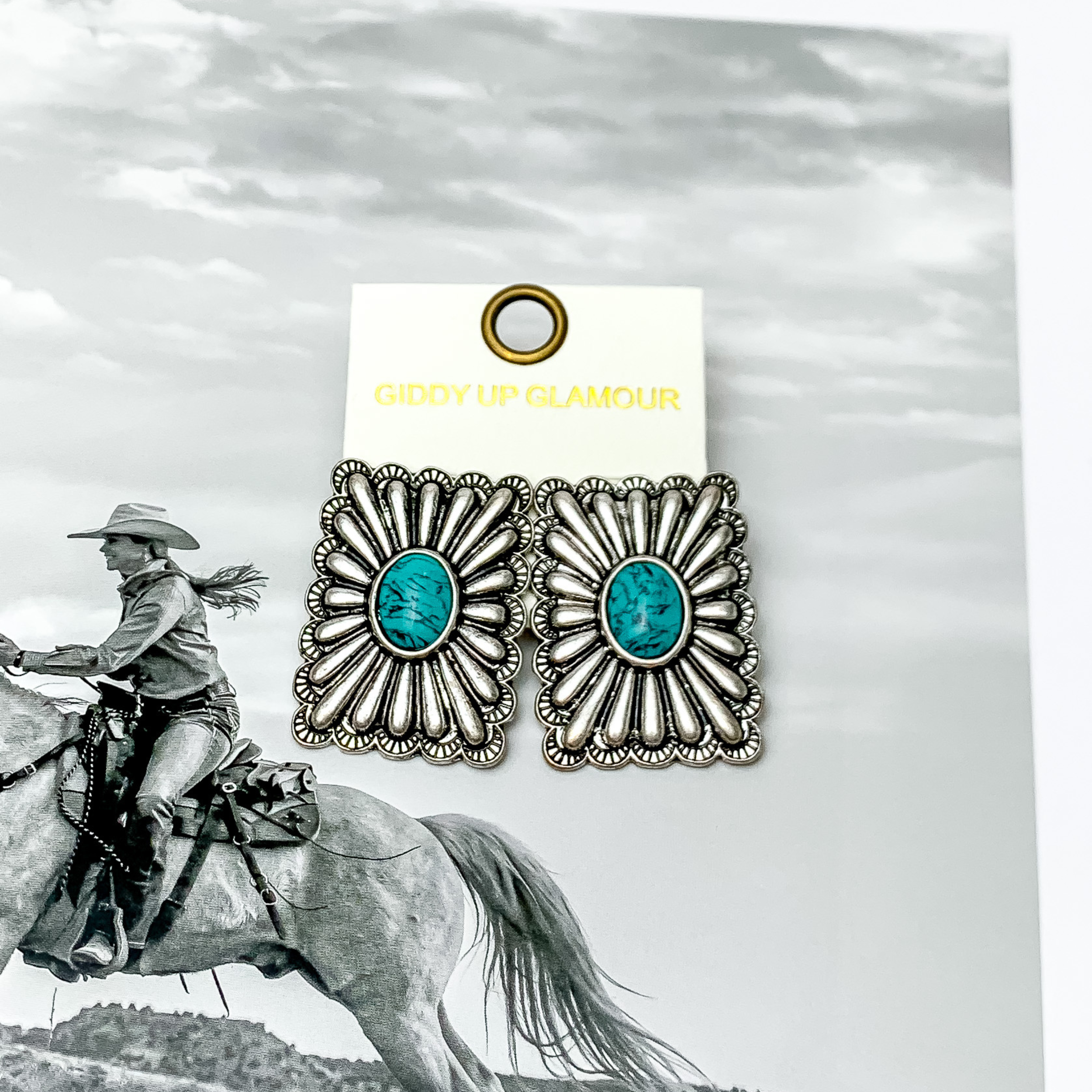 Western Flare Silver Tone Rectangle Earrings With Stone in Turquoise. Pictured on a western scene background.