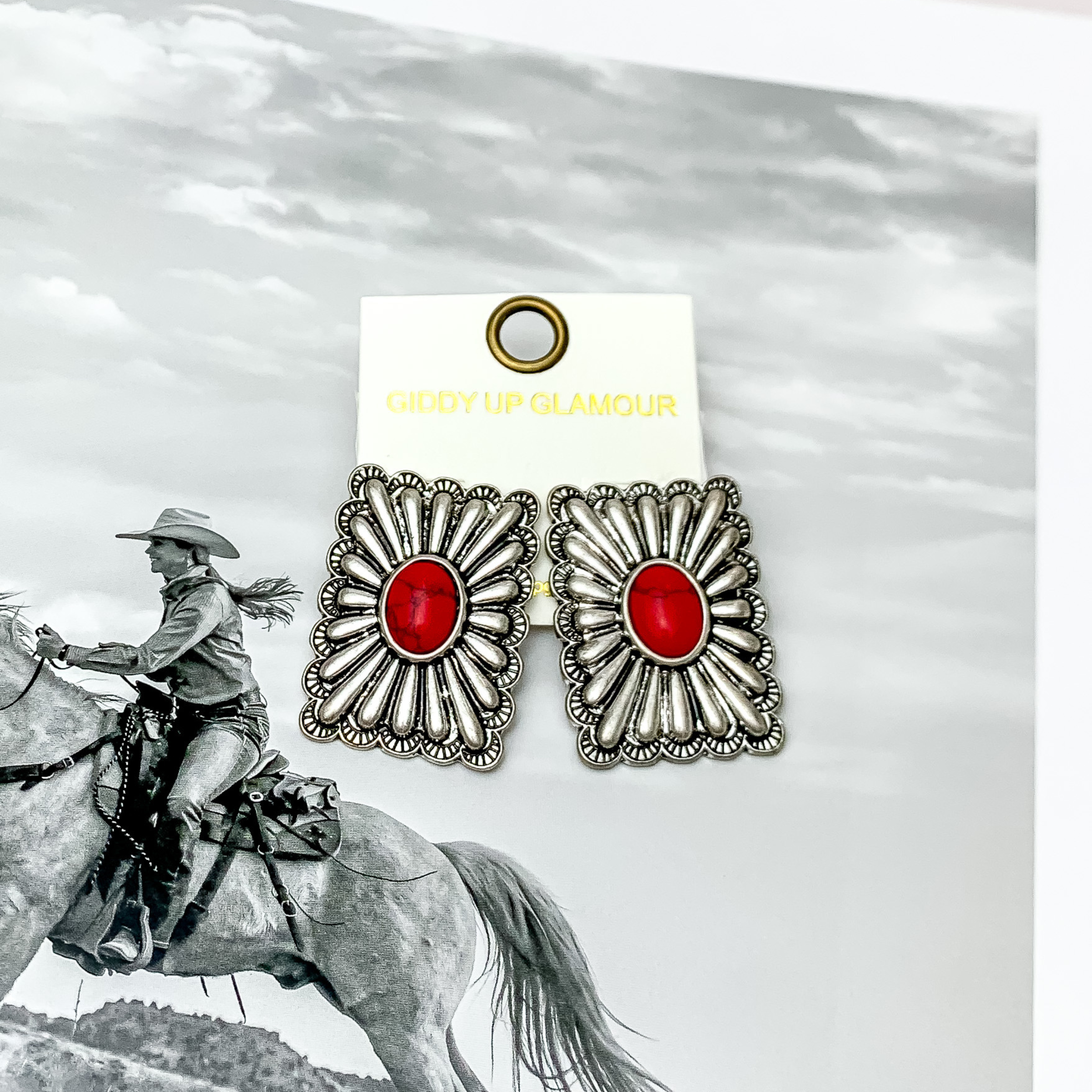 Western Flare Silver Tone Rectangle Earrings With Stone in Red. Pictured on a western scene background.