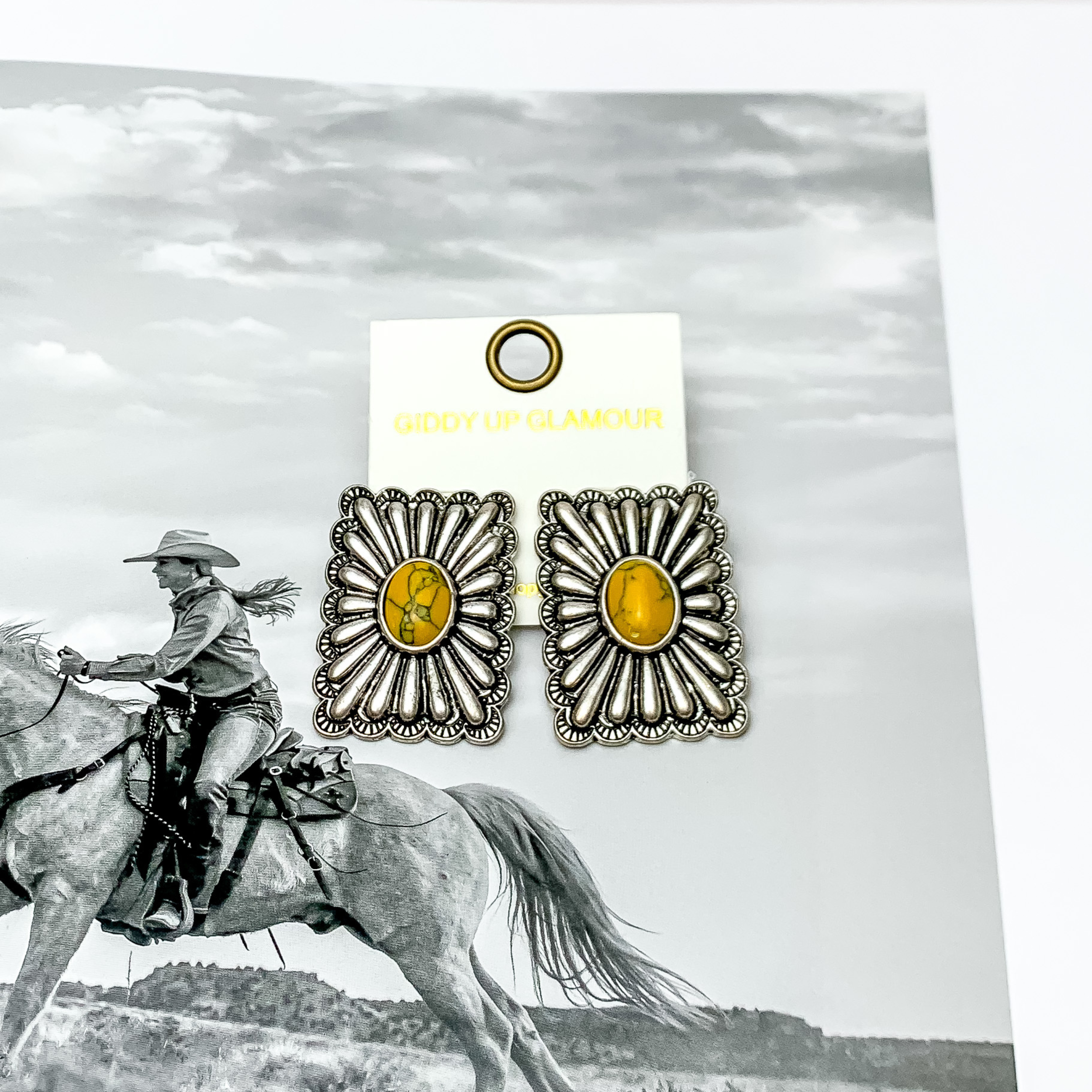 Western Flare Silver Tone Rectangle Earrings With Stone in Yellow. Pictured on a western scene background.