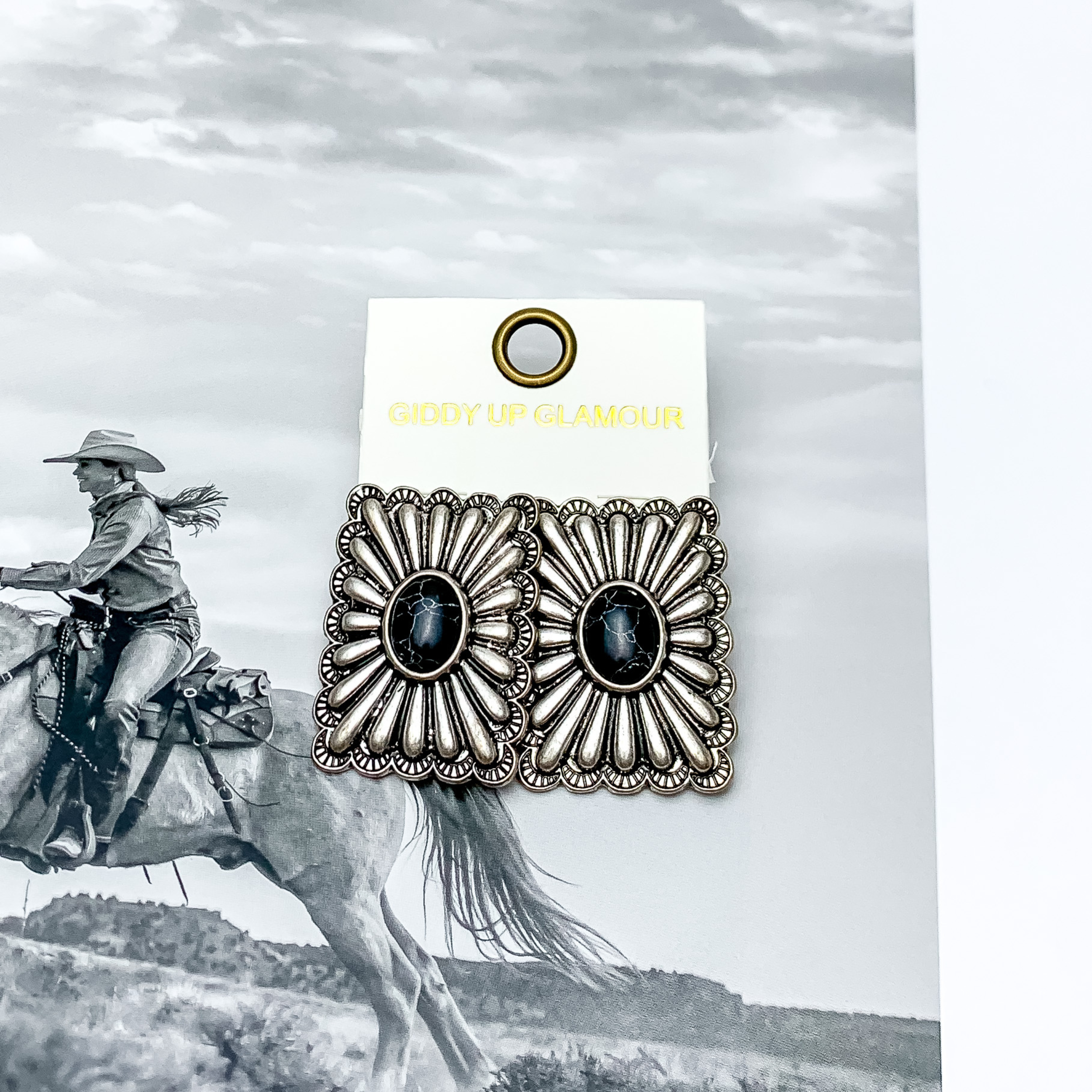 Western Flare Silver Tone Rectangle Earrings With Stone in Black. Pictured on a western scene background.