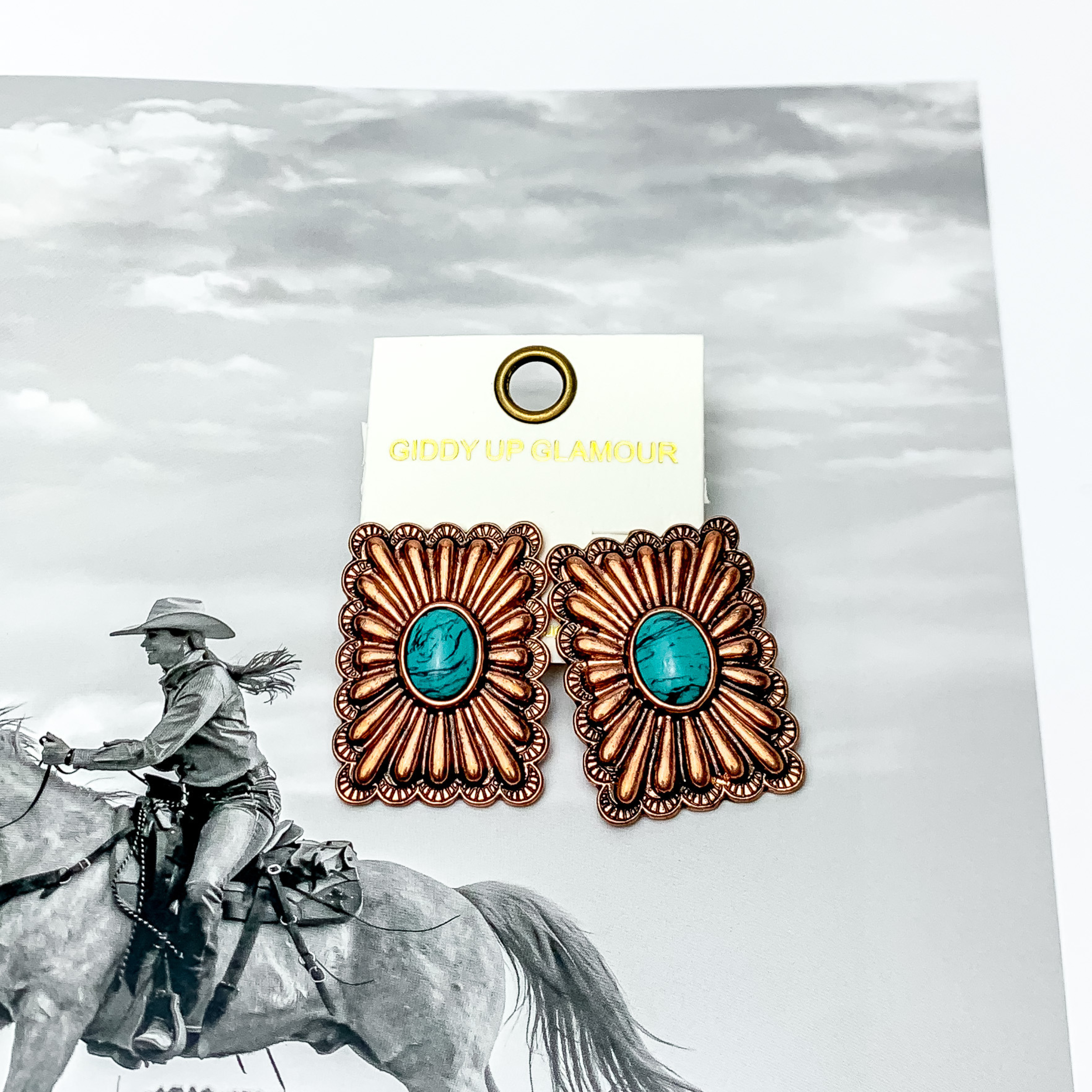 Western Flare copper Tone Rectangle Earrings With Stone in Turquoise. Pictured on a western scene background.