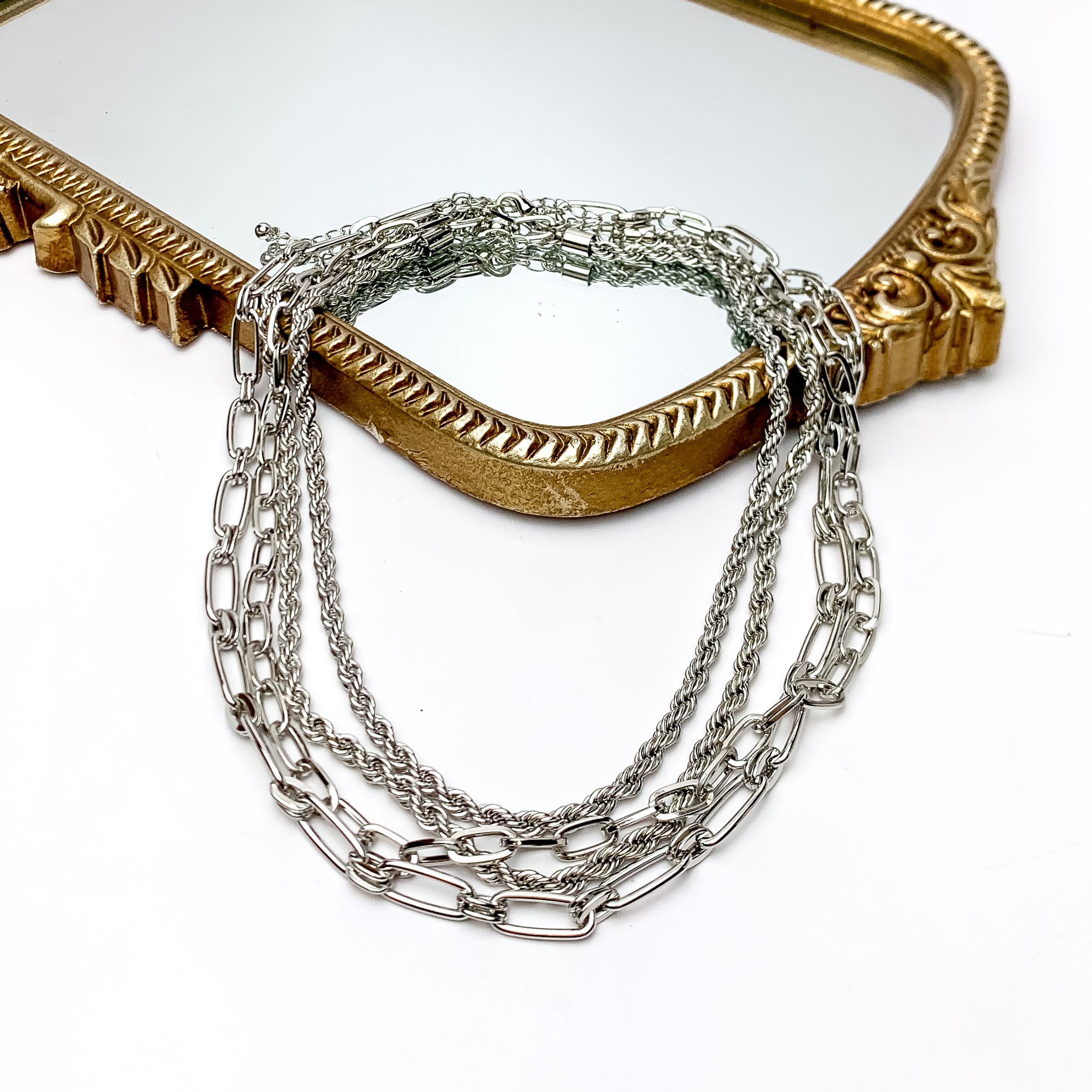 Sunday Style Silver Tone Chain Necklace. Pictured on a white background with part of the necklace on a gold framed mirror.